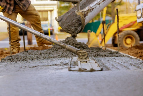 Workers leveling and smoothing freshly poured concrete for a durable surface.