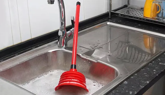 Toilet, sink, and faucet installation and repair in Wilmington, MA, with a plunger effectively unclogging a drain.