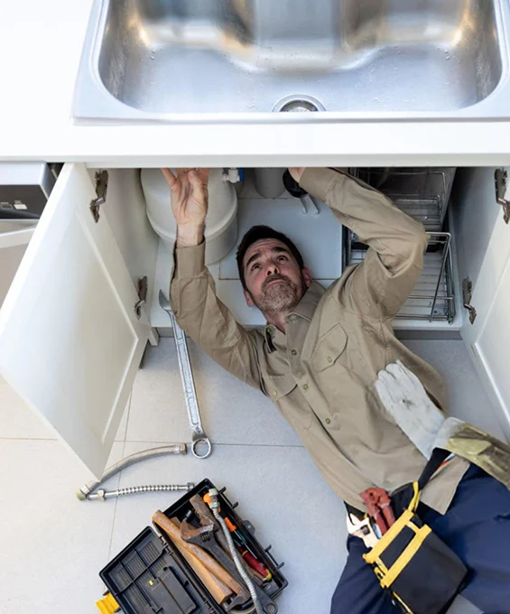 Handyman fixing sink, showcasing handyman services