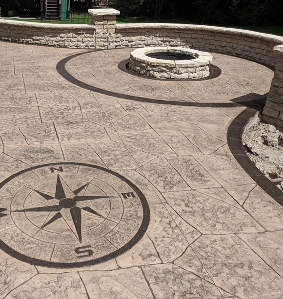 Stamped concrete patio in Boston, MA, featuring a decorative compass design, perfect for outdoor living spaces.